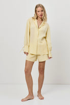 Woman wearing a yellow resort wear set on a white background