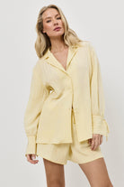 Woman wearing a light yellow resort wear set on a white background