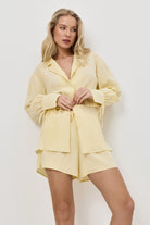 Woman wearing a light yellow resort wear set against a white background
