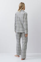 Person wearing a checkered pajama set on a white background