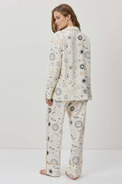 Person wearing a patterned pajama set on a white background