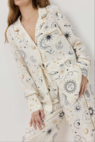 Woman wearing a long, patterned robe against a plain background