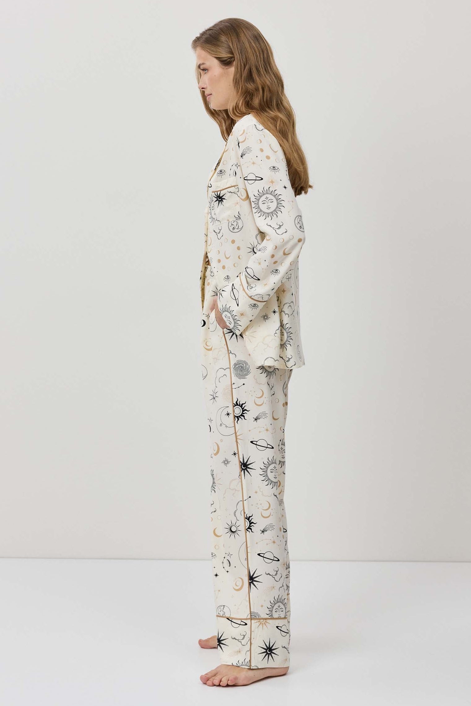 Woman wearing a long-sleeve pajama set with a floral pattern on a white background
