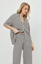 Woman wearing a patterned pajama set on a plain background