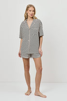 Woman wearing a patterned pajama set on a white background