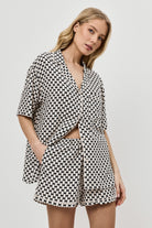 Woman wearing a patterned pajama set on a plain background