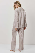 Person wearing a beige pajama set against a white background