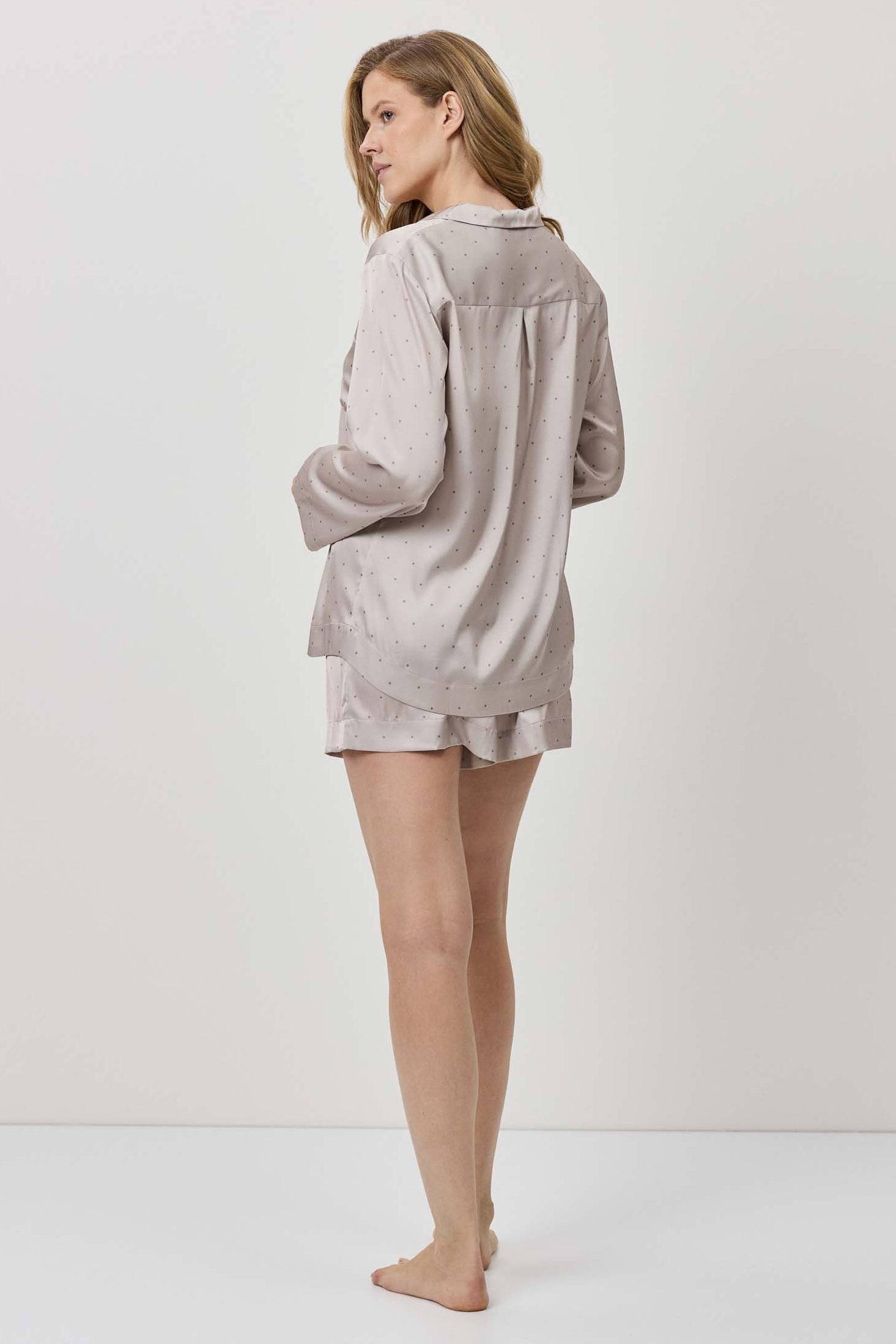 Woman wearing a light gray loungewear set on a white background
